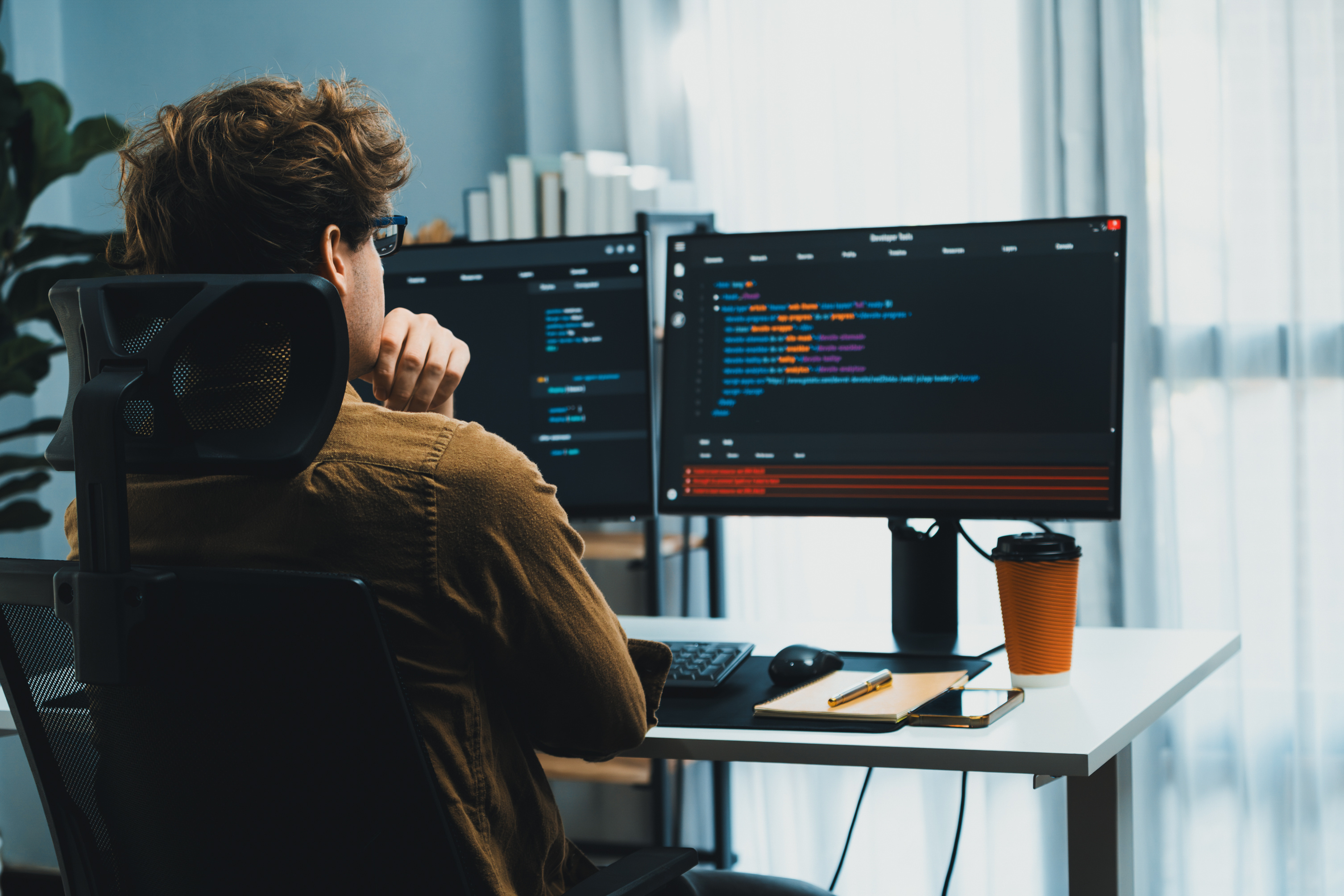 IT developer working online software development coding on pc screens. Gusher.